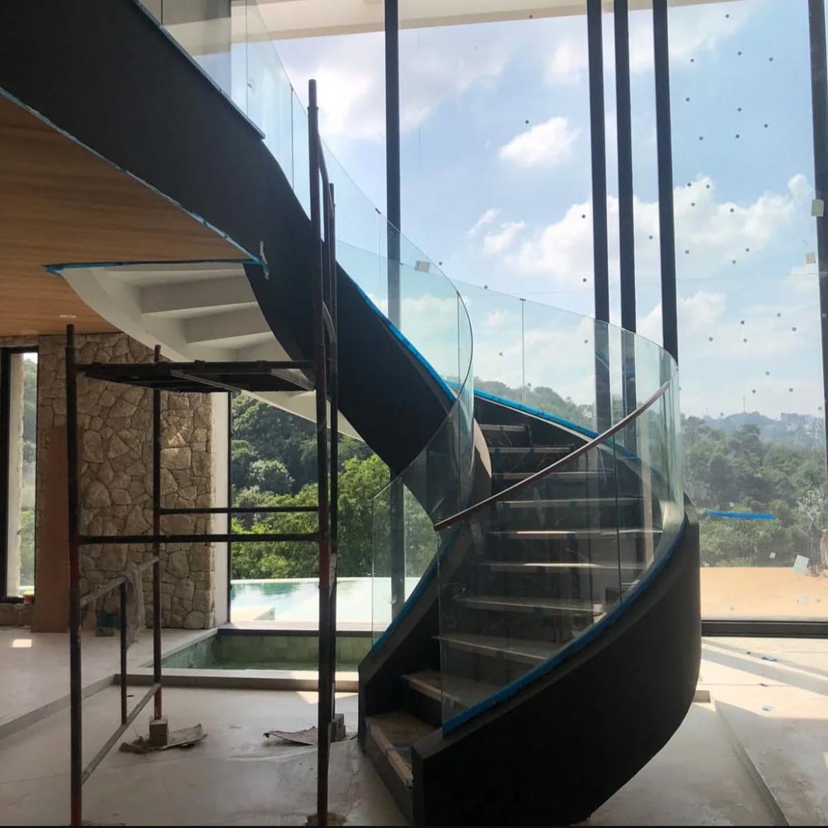 Guarda-corpo em vidro curvo engastado para escada arquitetônica.