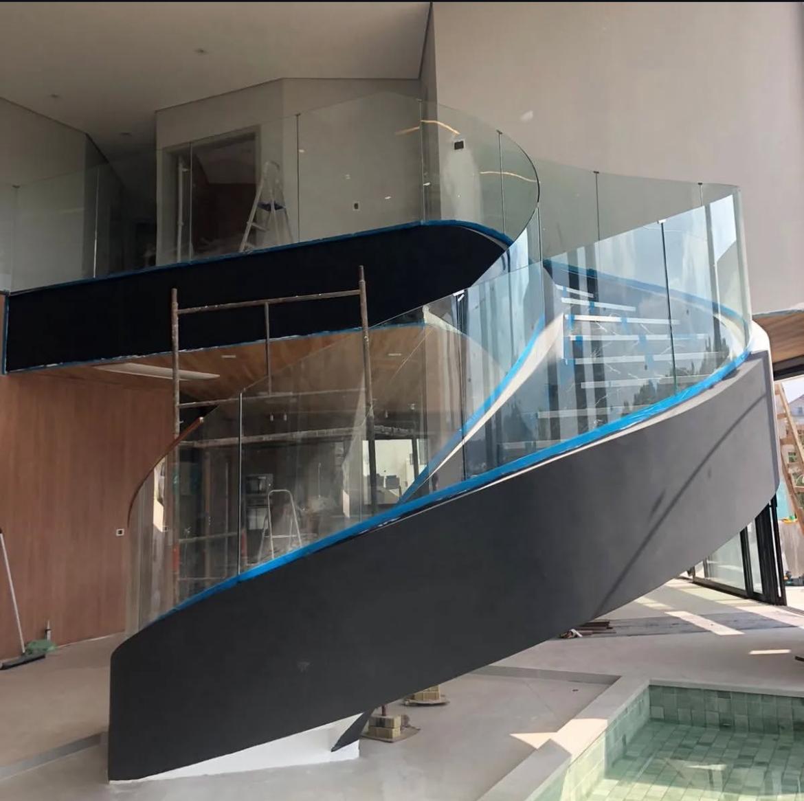 Guarda-corpo em vidro curvo engastado para escada arquitetônica.